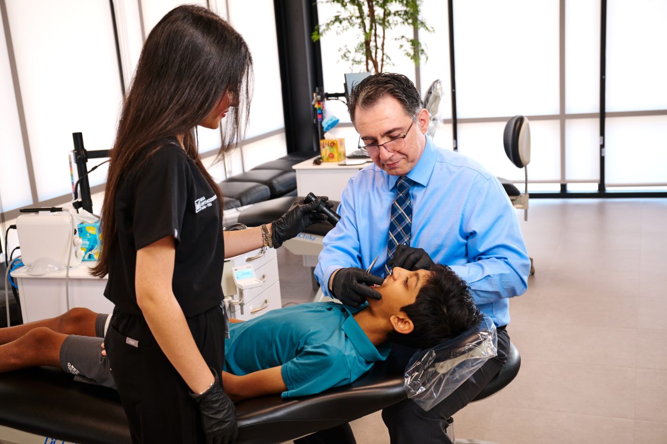 Orthodontist examining a patient's teeth in a modern clinic setting.