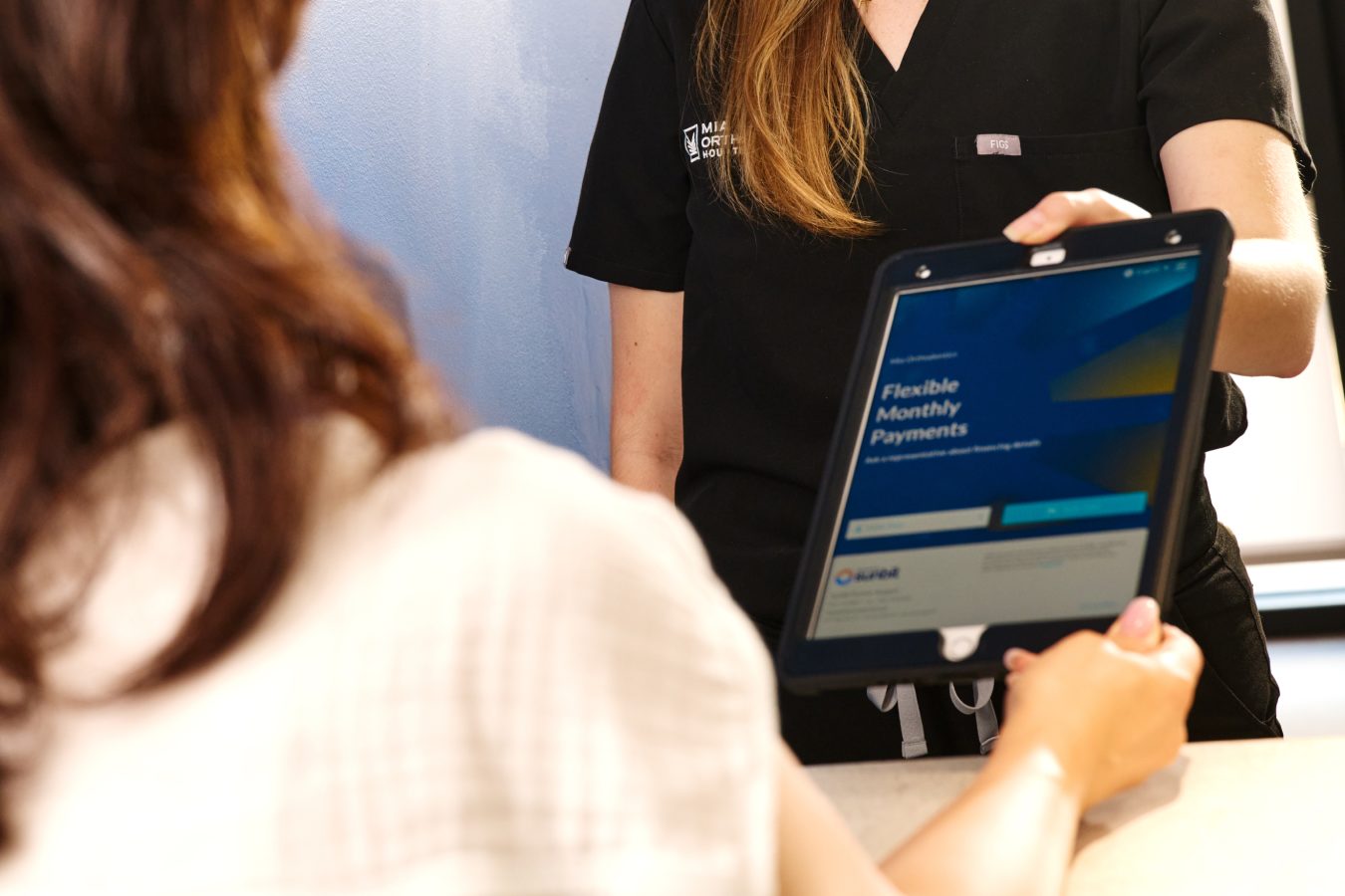 Patient paying with tablet for orthodontic services at Mia Orthodontics.